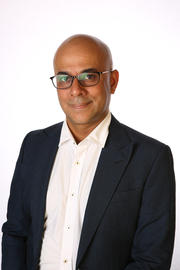 Headshot of Ahmar Mahboob, wearing a suit with an open-necked shirt